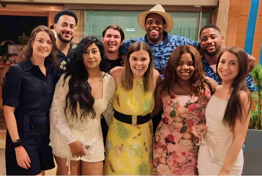 Nine people smiling and posing in a group at a team social event